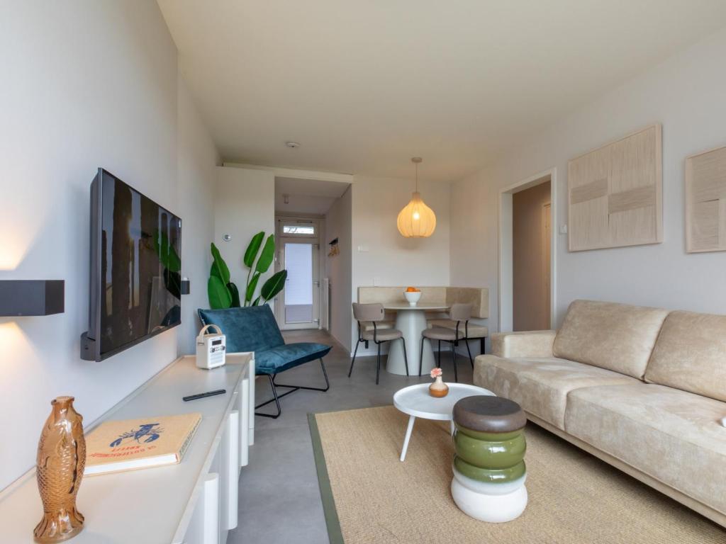 a living room with a couch and a table at Zoutelande Retreat by Sea in Zoutelande