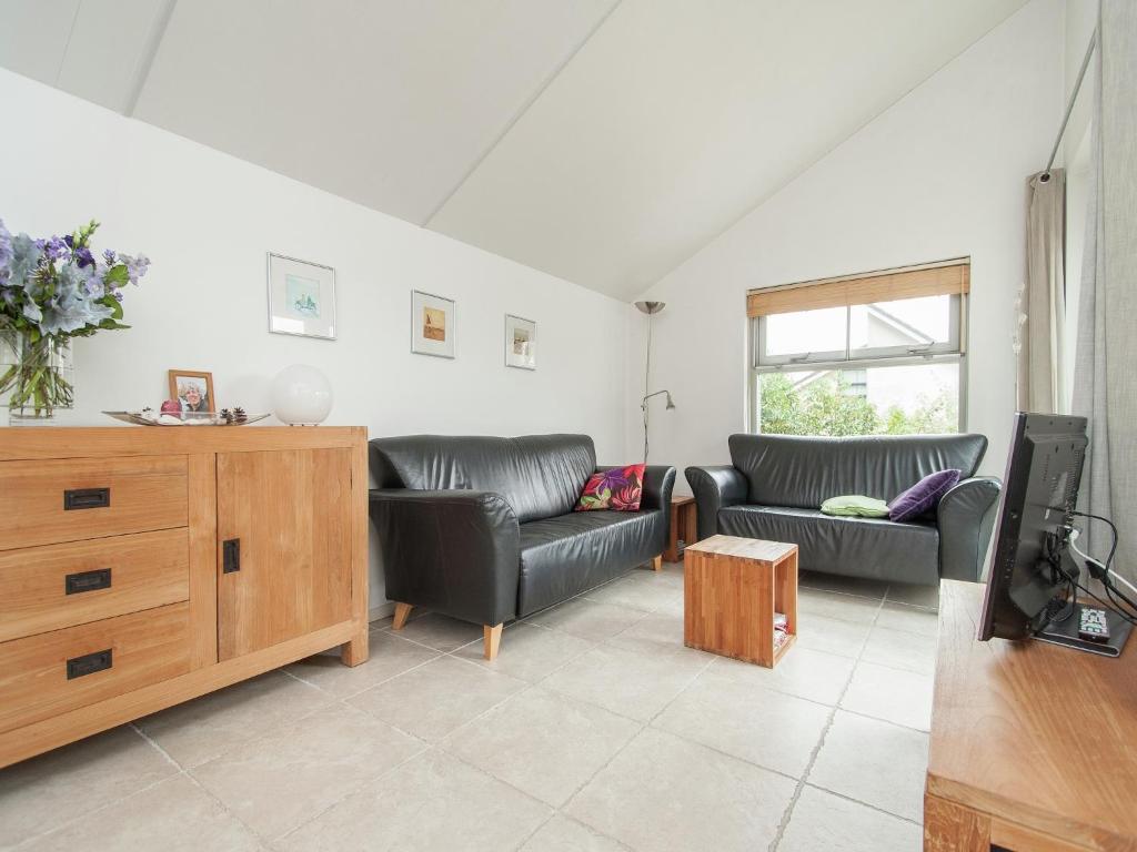 a living room with two couches and a tv at Holiday Home in Schoorl near Dunes in Schoorl