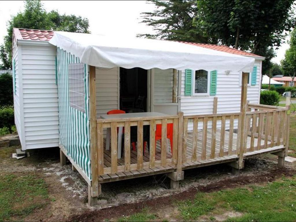 a small house with a canopy on a deck at Mobil home 2 chambres avec terrasse - API-1-52-478 in Brétignolles-sur-Mer