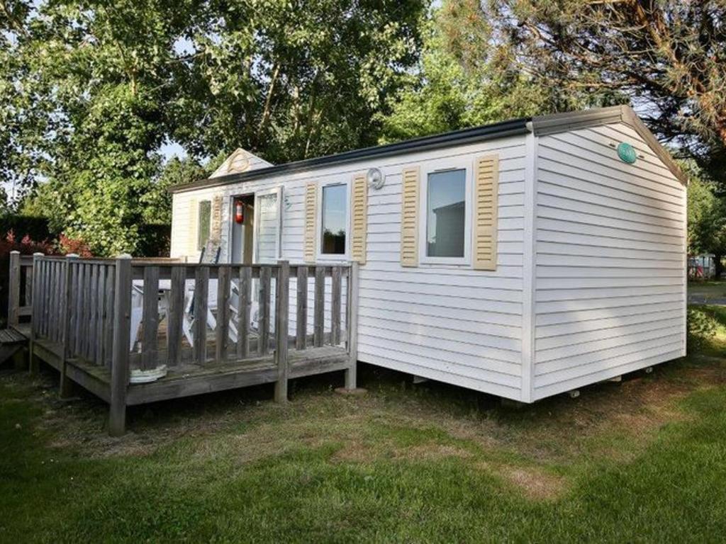 a white tiny house with a wooden fence at Mobil-home 2 chambres avec terrasse - API-1-52-456 in La Mothe-Achard