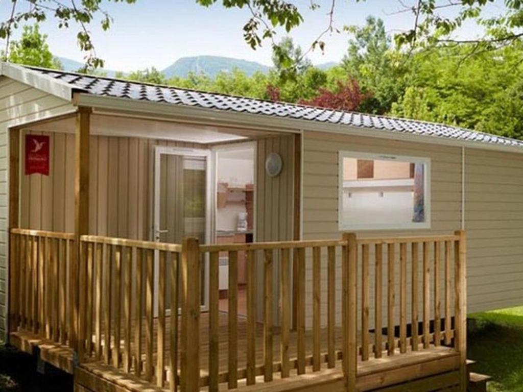 a small cabin with a porch and a deck at Mobil home 5 pers à Avrillé avec terrasse - API-1-52-587 in Avrillé