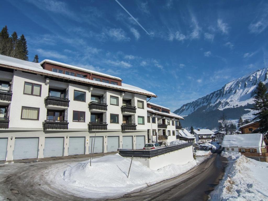 a large white building with snow in front of a mountain at Apartment in Riezlern near Ski Slope 