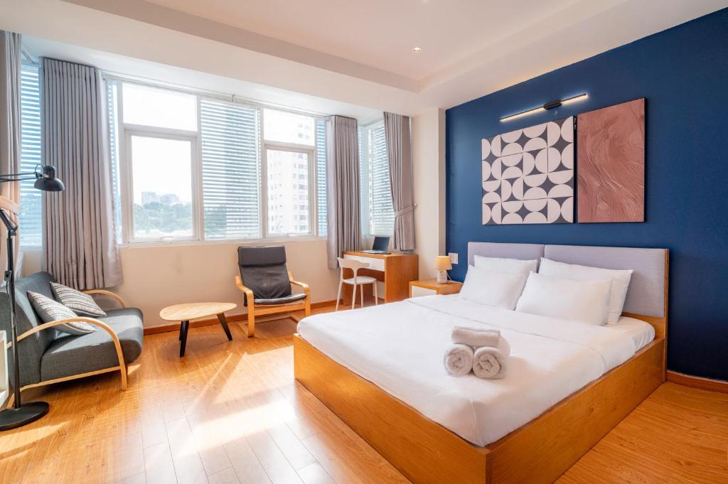 a bedroom with a large bed with a blue wall at Hoshi Apartment in Ho Chi Minh City