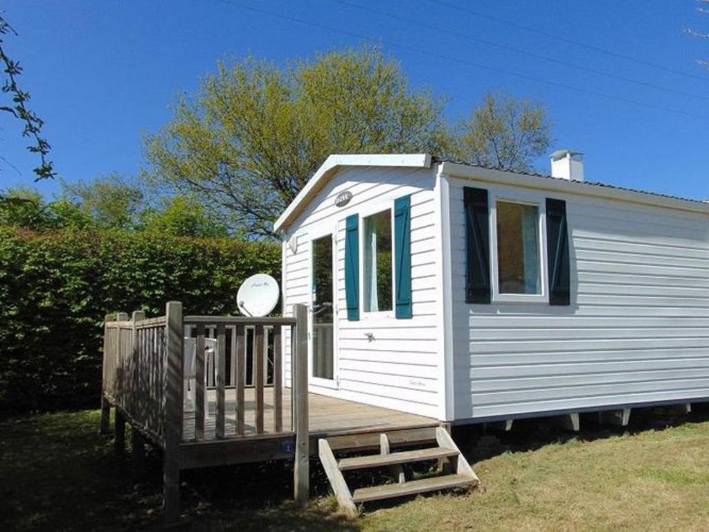 a small white house with a porch and a wooden ramp at Mobil-home cosy avec terrasse à Avrillé - API-1-52-490 in Avrillé
