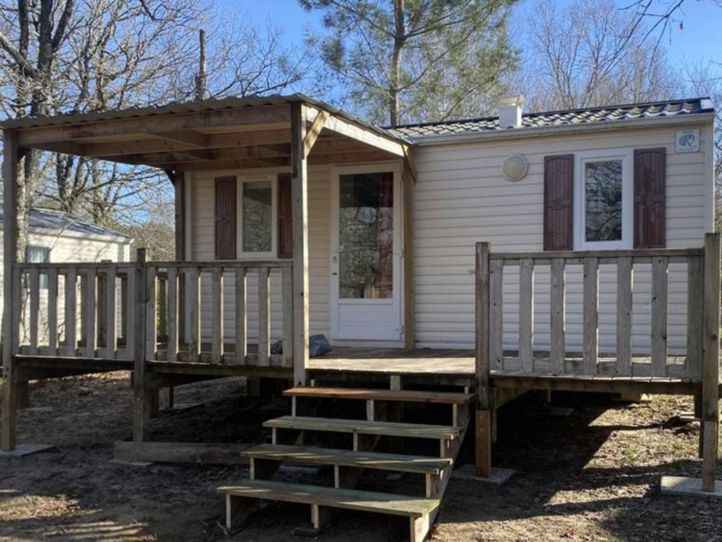 a small white house with a porch and a ladder at Mobil-home cosy avec terrasse pour 2 personnes - API-1-52-575 in Le Fouilloux