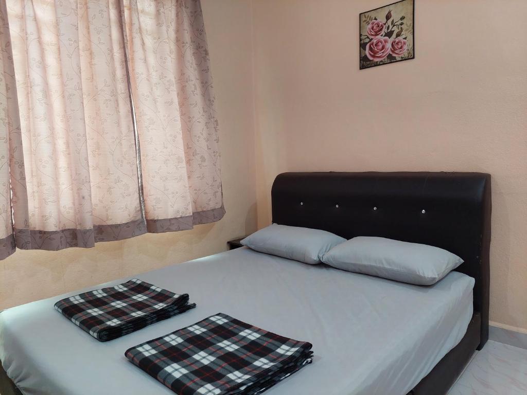 a bed with two pillows on it with a window at Rose Homestay Padang Besar in Padang Besar