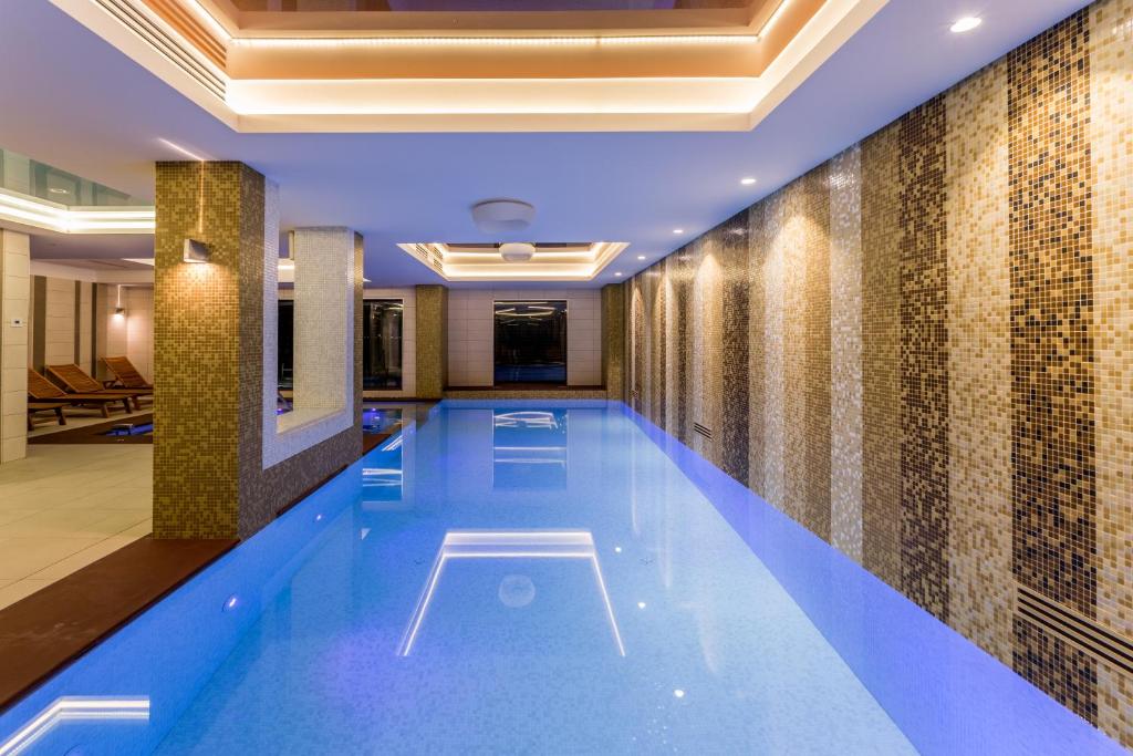 - une piscine dans un hôtel doté d'un mur en carrelage dans l'établissement New Splendid Hotel & Spa - Adults Only (+16), à Mamaia