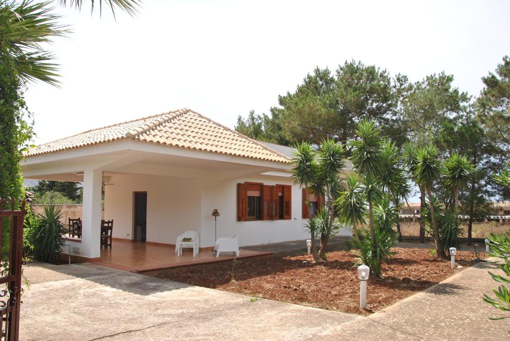 Casa blanca pequeña con porche y árboles en Villa Messi, en Castelluzzo
