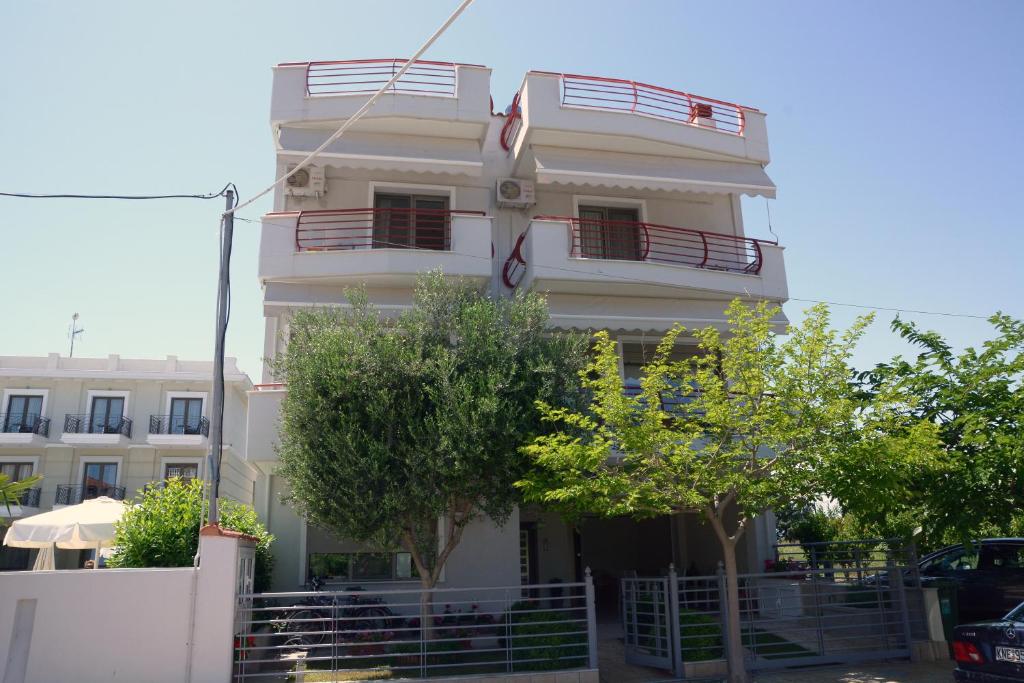 un edificio blanco con un balcón en el lateral. en ioli, en Olympiakí Aktí