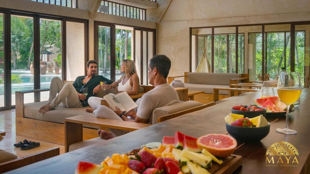 a group of people sitting in a living room with fruit at Peregrina Tulum 109 1BR Luxury Condo in Tulum