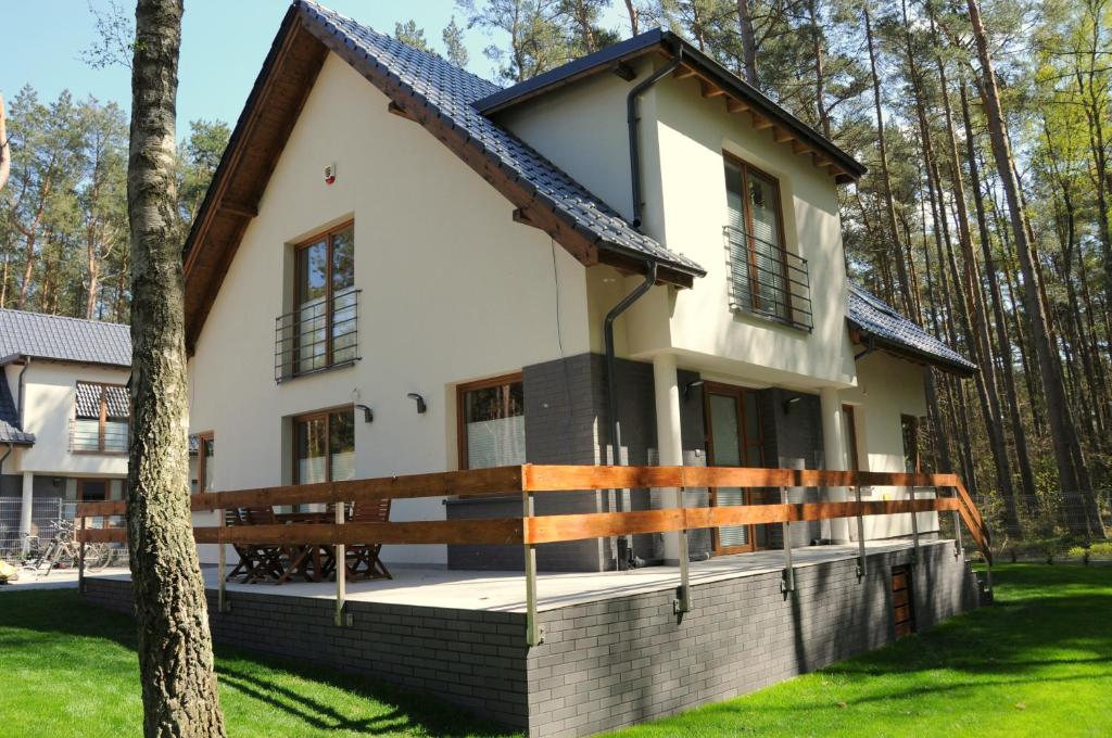 una casa rodeada de un porche con un árbol en Zielony Zakątek, en Łukęcin