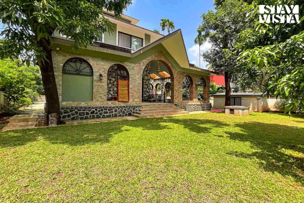 a house with a lawn in front of it at StayVista at Villa Harmony with Bonfire, Pool in Alibaug