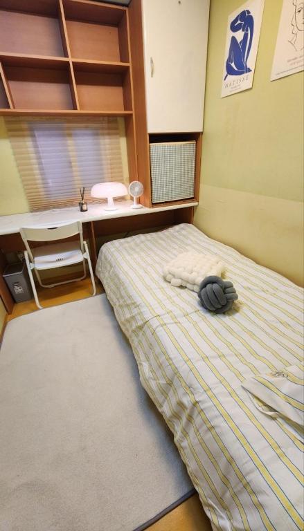 a bedroom with a bed with a hat on it at Time Stay in Busan