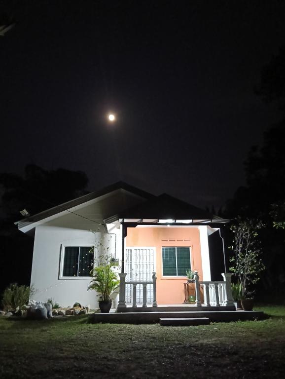 a small house at night with a moon at Air Puteri Rest House in Mersing
