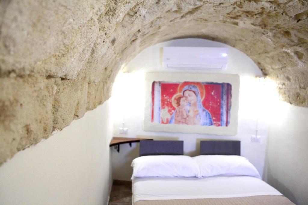 マテーラにあるLa Pergola ai Sassiの石壁のベッドルーム1室(ベッド2台付)