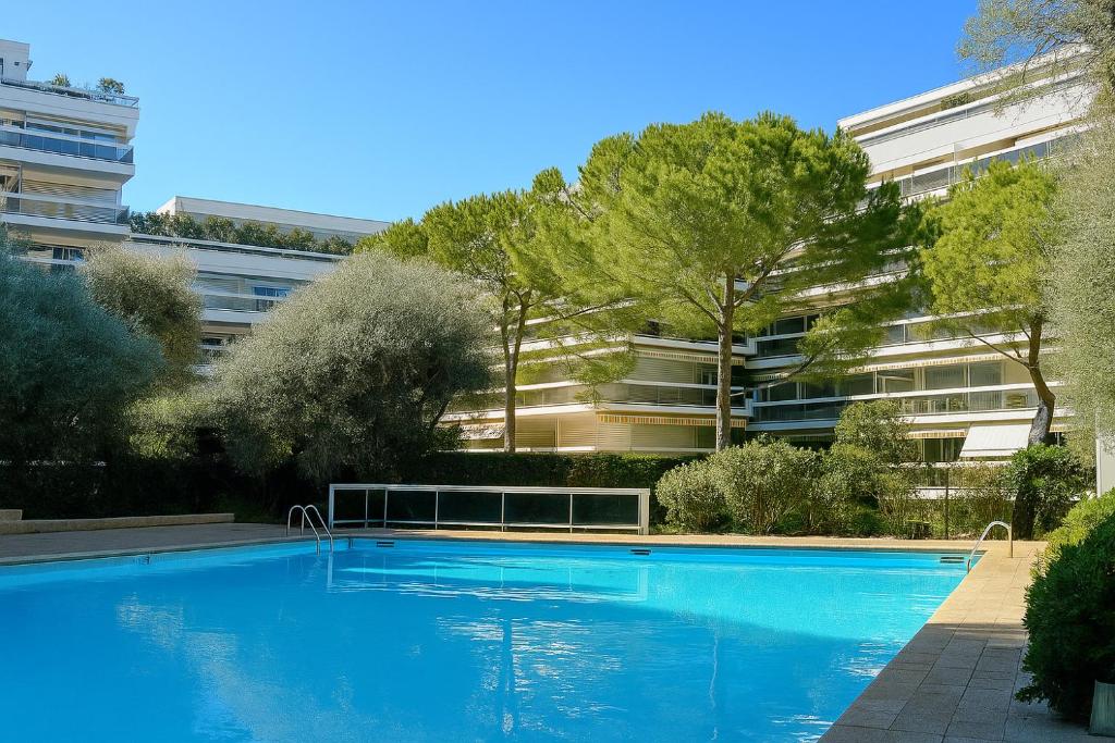 une grande piscine bleue devant un immeuble dans l'établissement Appartement avec Piscine, Quartier calme proche centre et plages d'Antibes, à Antibes