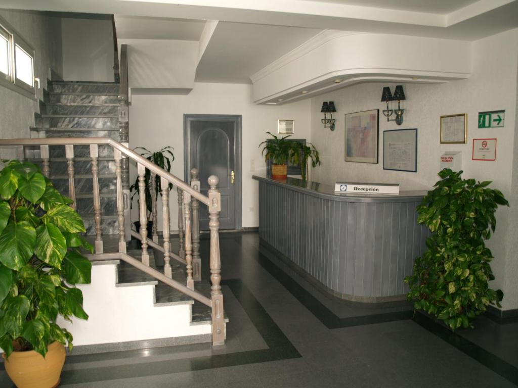 a lobby with a staircase and potted plants at Hotel San Jorge in Alcalá de los Gazules