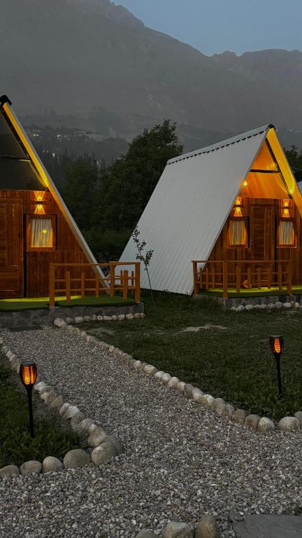 a large wooden cabin with lights in front of it at Fortyard Cottages Hunza in Karimabad Hunza