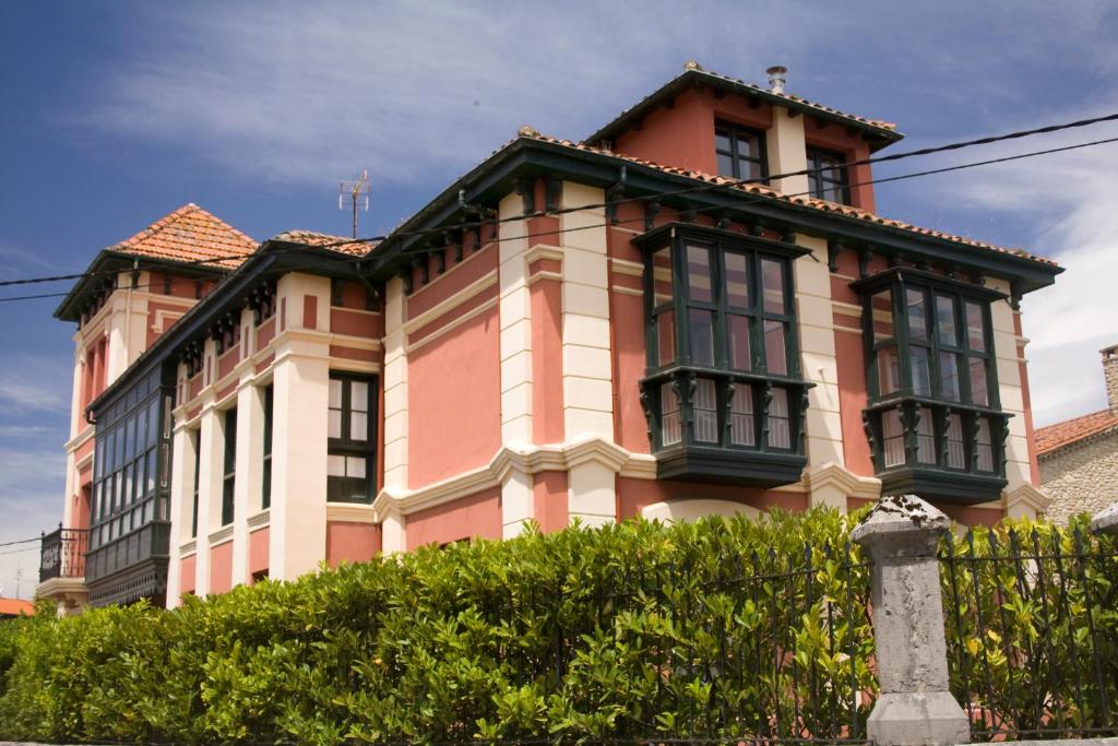 un gran edificio rosa con muchas ventanas. en Apartamentos Turísticos La Solana, en Colombres