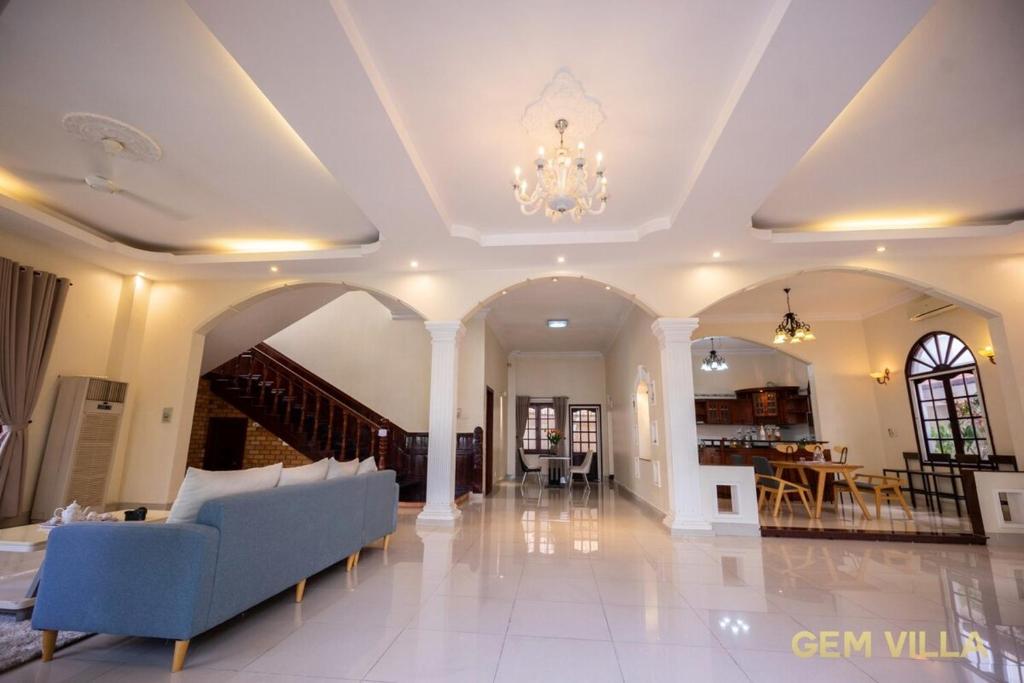 a living room with a couch and a dining room at Gem Villa 10 - 5 Big Bedroom Big Pool Big Garden in Ho Chi Minh City