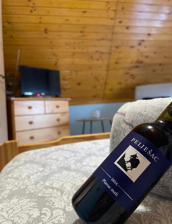 a bottle of wine sitting on top of a bed at Apartman "SaraP" Metković in Metković