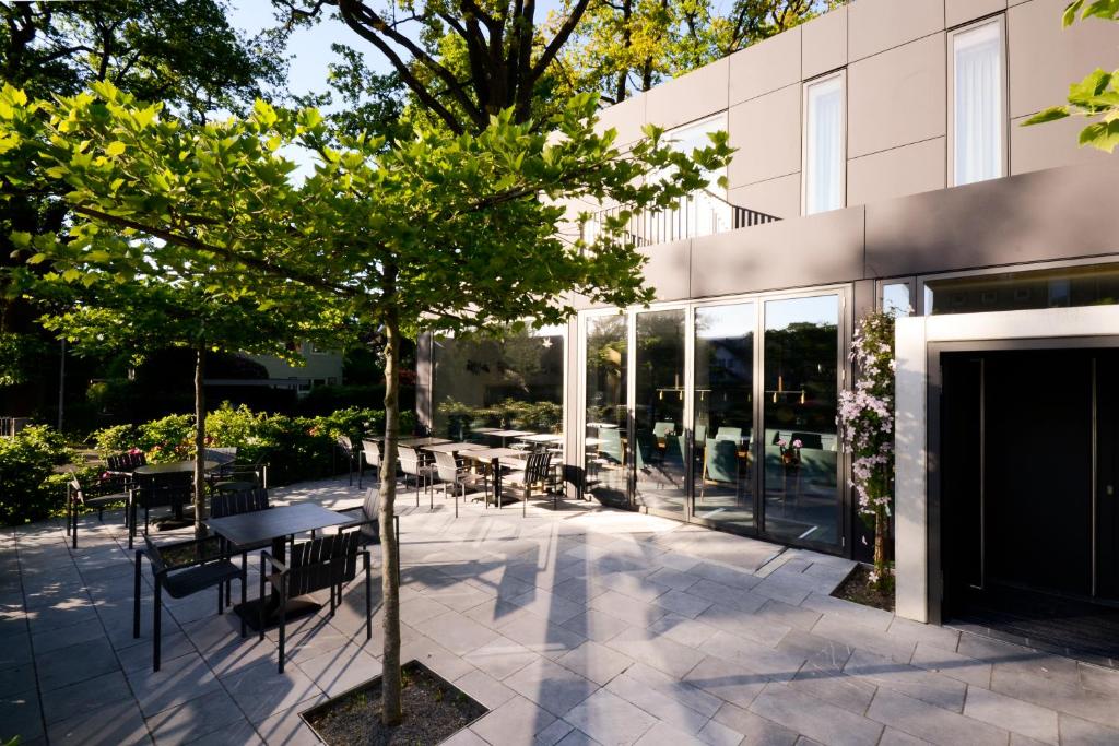 a patio with tables and chairs in front of a building at sevenoaks in Cloppenburg