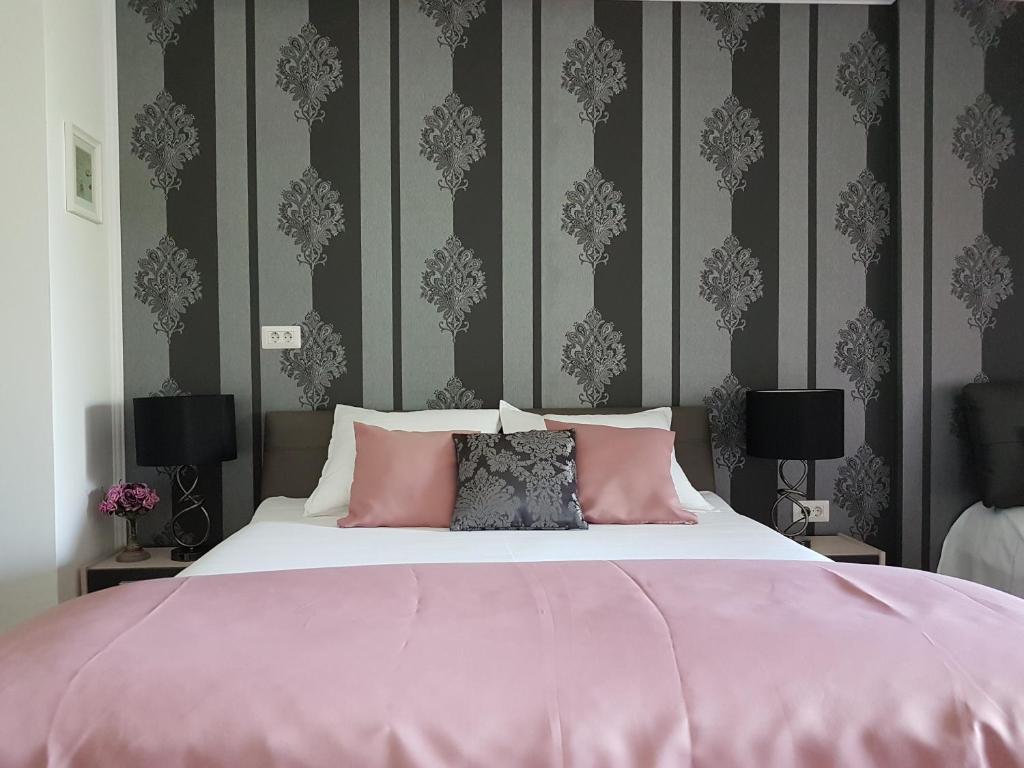ママイアにあるBlue Bike Studioのベッドルーム1室(ピンクの枕が付いた大型ベッド1台付)