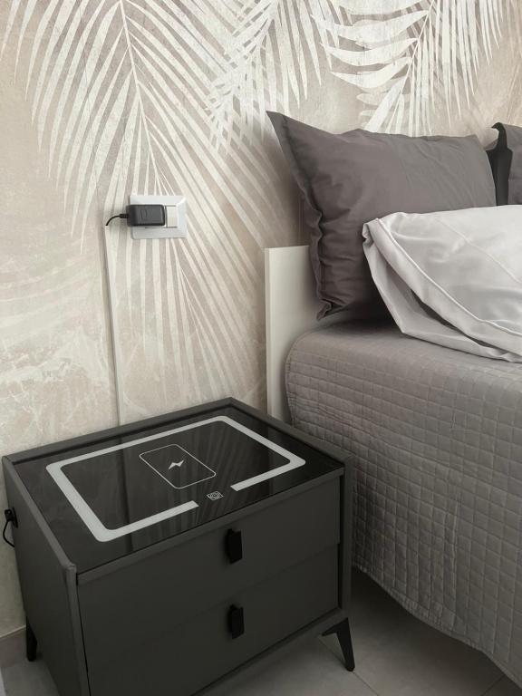 a sink on a night stand next to a bed at La Pola House Cagliari in Cagliari
