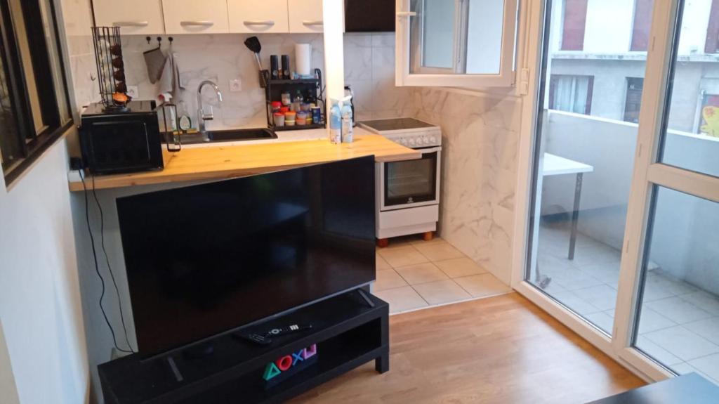 Appart cosy proche de Paris في فيلوجويف: مطبخ بميكرويف واجهزة سوداء