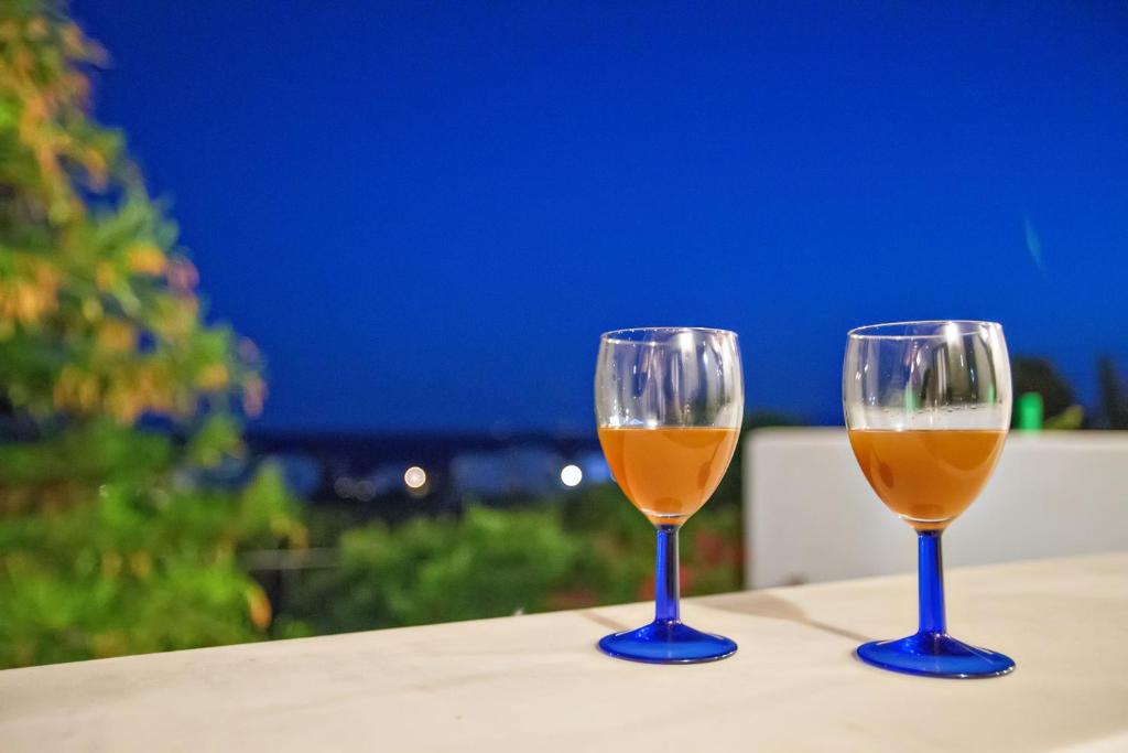 dwa kieliszki wina siedzące na stole w obiekcie Parathyro Sto Aigaio 1 w mieście Tinos
