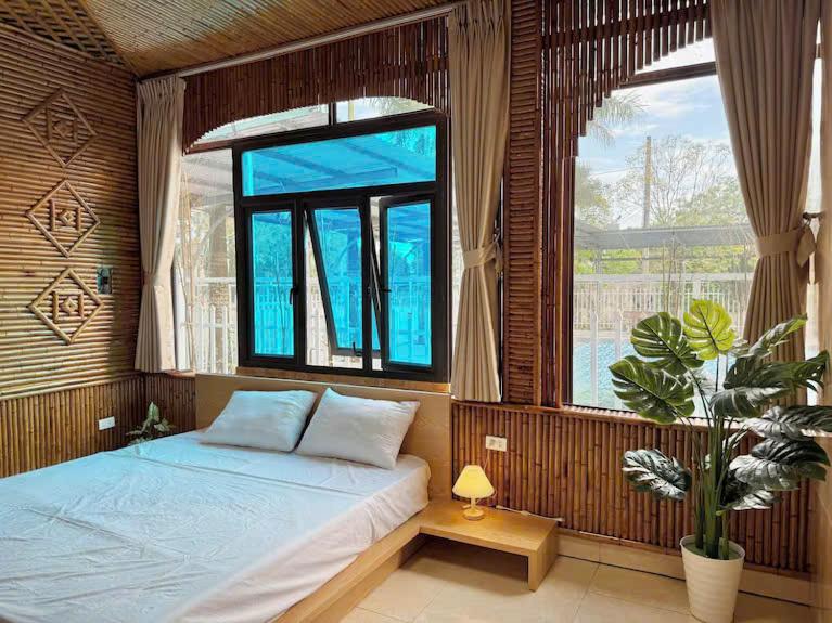 une chambre avec un lit et une grande fenêtre dans l'établissement May Garden Homestay Ninh Bình, à Phúc Trì