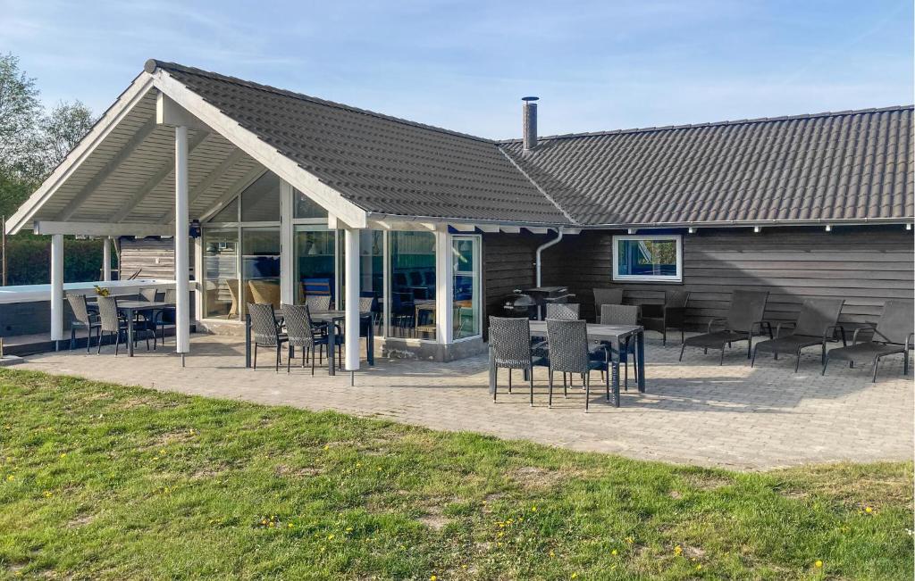 a pavilion with chairs and tables in front of a building at Holiday Home Vibelunden Rødby X in Kramnitse