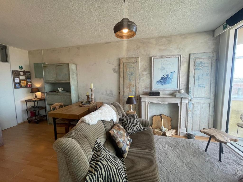 ein Wohnzimmer mit Couch und Kamin in der Unterkunft Sun Beach Nieuwpoort-Bad in Nieuwpoort