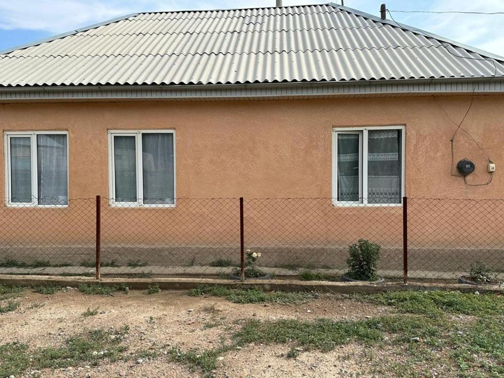 a house with a fence in front of it at NUR House in Kara-Koo