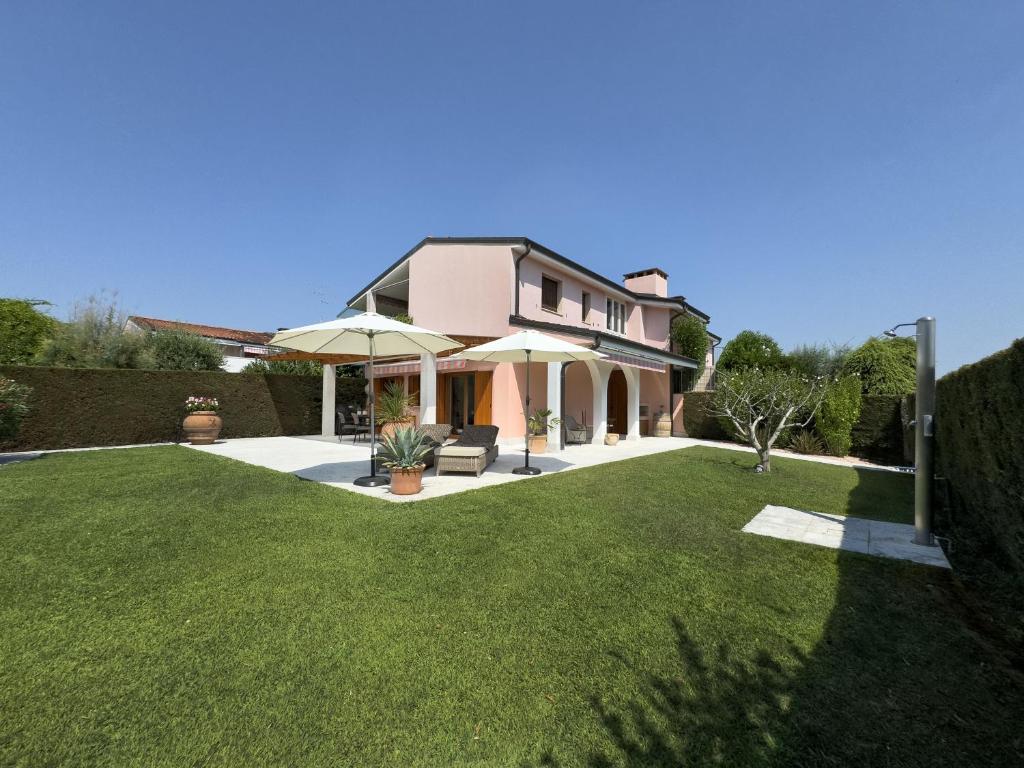 a house with a lawn with an umbrella at Ca' dei Vigneti in Colà di Lazise