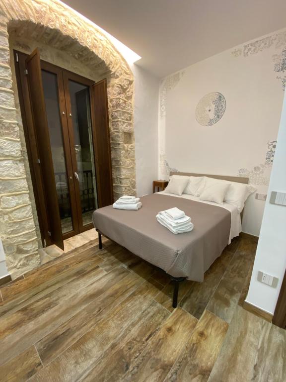 a bedroom with a bed and a stone wall at Dimora San Valentino in Vico del Gargano