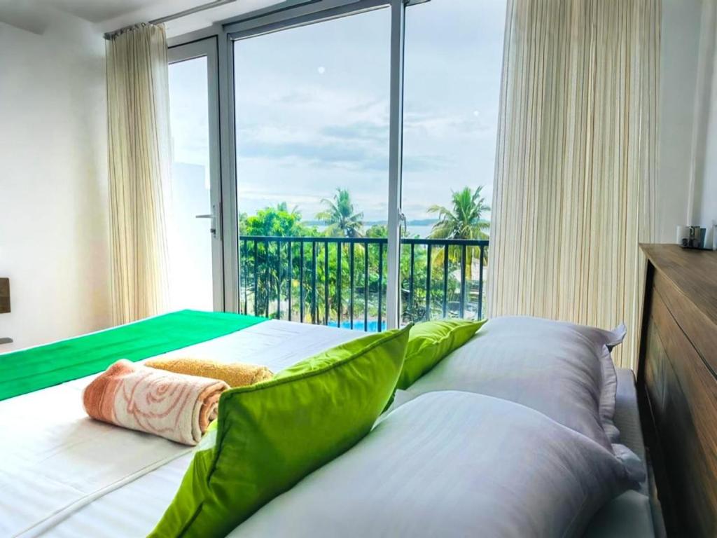 ein Schlafzimmer mit einem Bett mit einem großen Fenster in der Unterkunft Villa Serenity - Jayavikumgama in Weligama