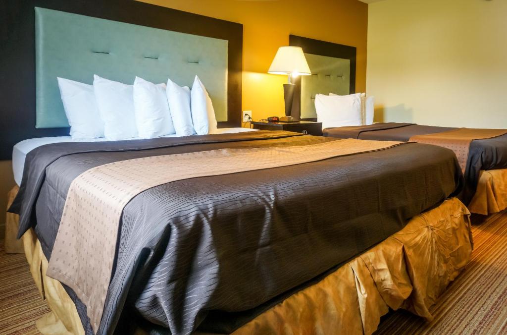 Habitación de hotel con 2 camas y almohadas blancas en Cocoa Country Inn Hershey, en Hershey