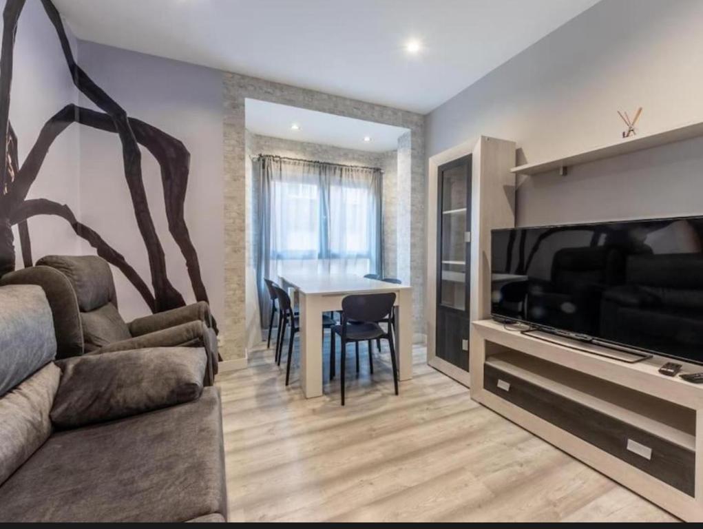 a living room with a couch and a tv and a table at La Bondad apartamento in Barakaldo