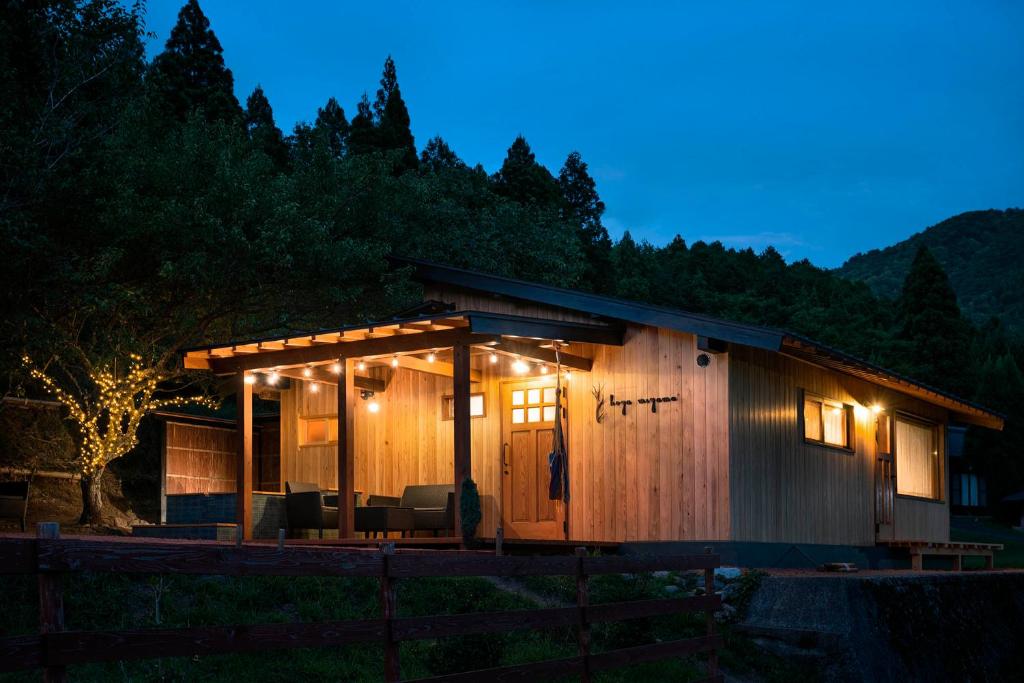 a wooden cabin with lights on it at night at Koya Miyama in Nantan city