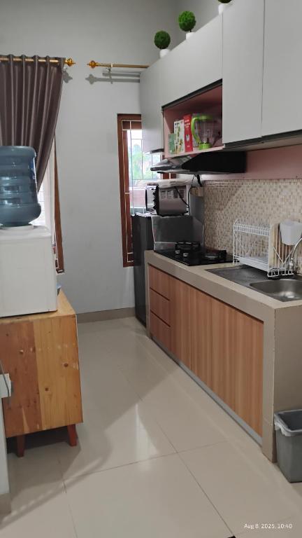 a kitchen with a stove and a counter top at Varisha Homestay 2 Bedrooms, PS5, E-bike in Ngaglik