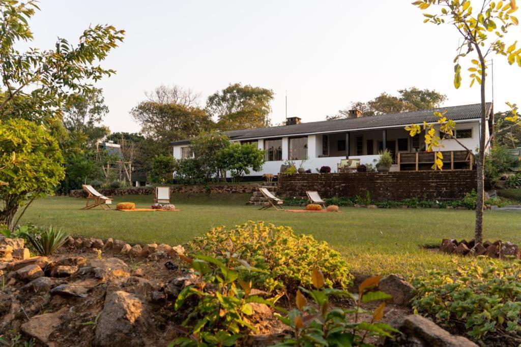 Una casa con dos pájaros sentados en el patio. en Ntchisi Forest Lodge, 