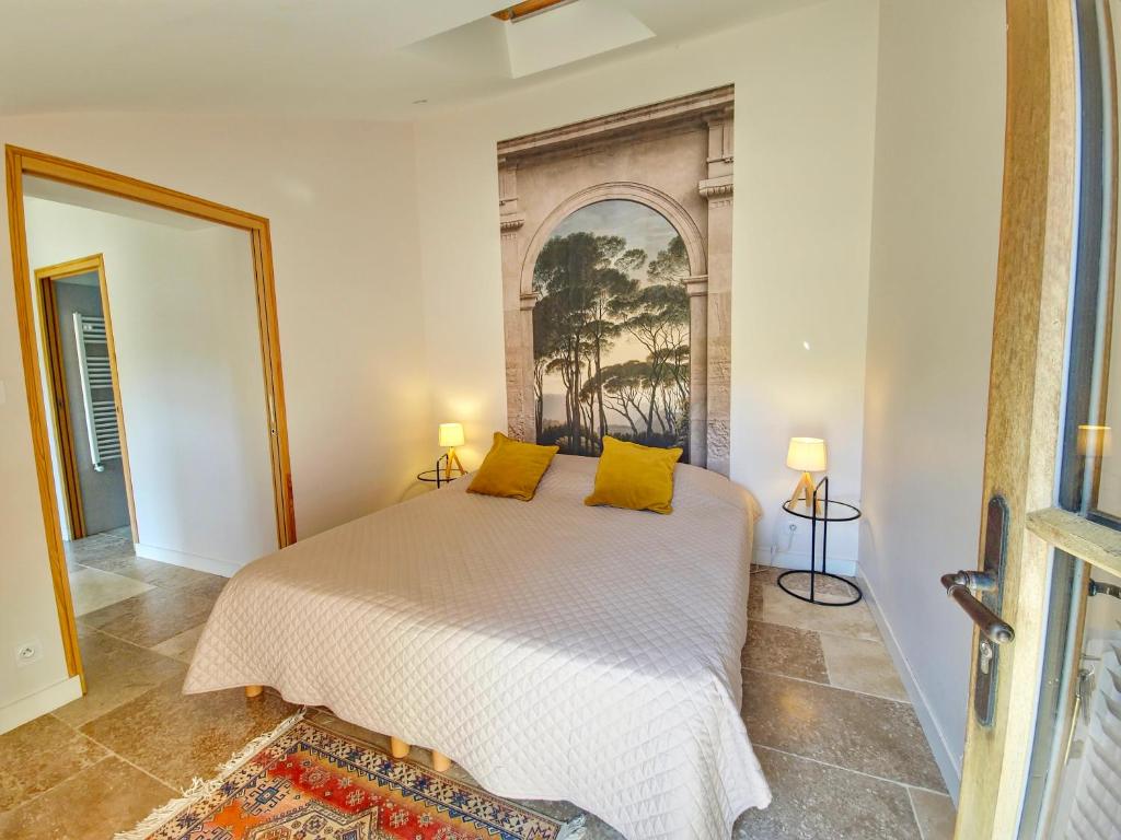 a bedroom with a bed with yellow pillows on it at Les Gîtes du chateau de Craon in Craon