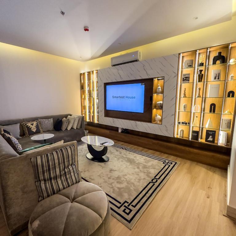 a living room with a couch and a flat screen tv at Luxury Smart Apartment B12 in Riyadh