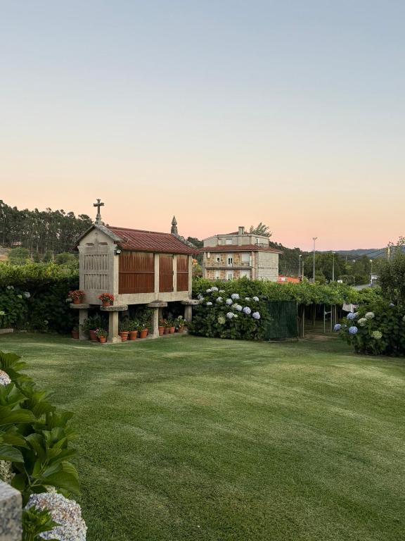 a large yard with a house and a church at Casa Fuentes in Poio