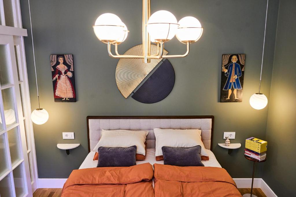 a bedroom with a bed and some pictures on the wall at Central oLiv Apartment with free parking in Timişoara