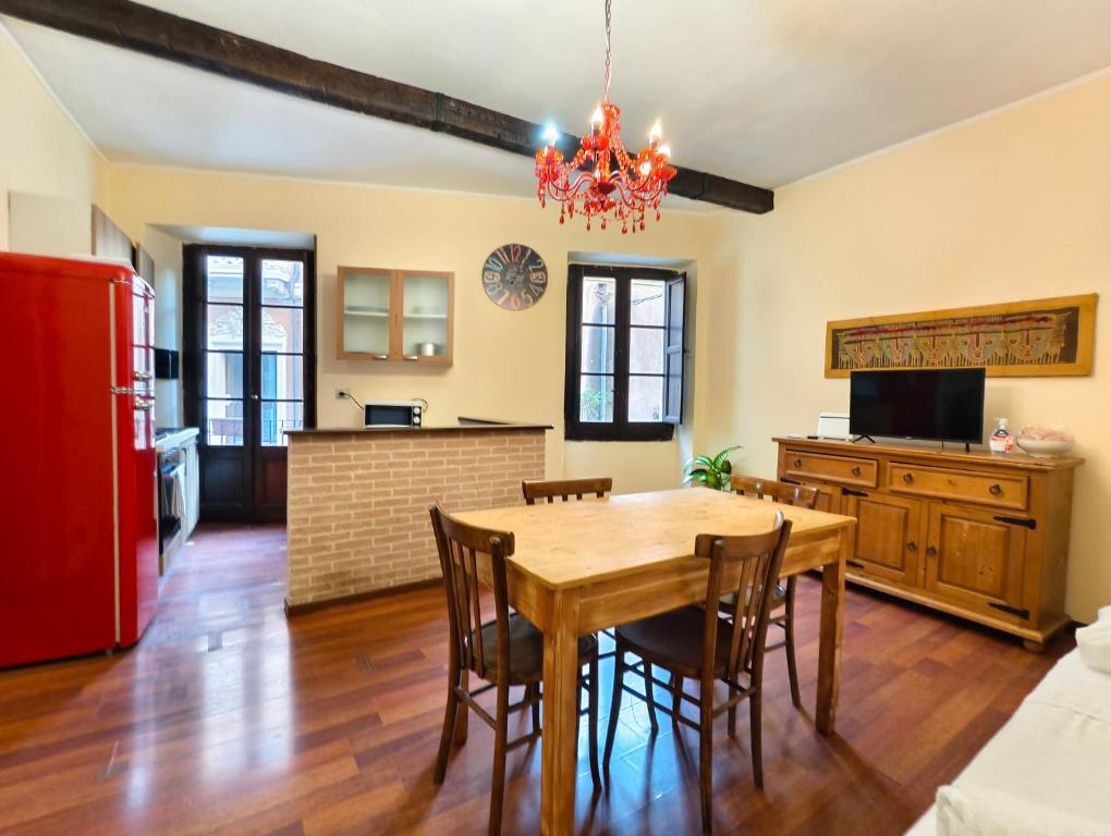 a kitchen and dining room with a wooden table and chairs at Eulalia Apartment in Cagliari