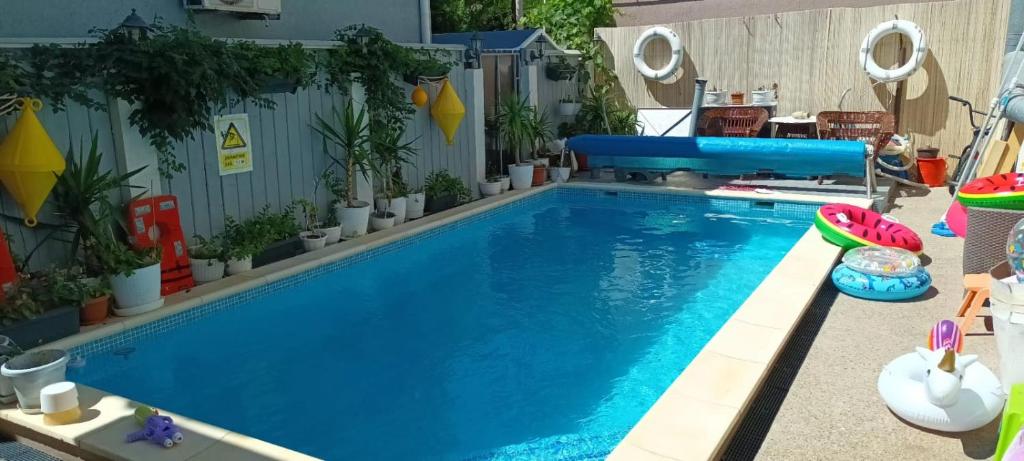 a large blue swimming pool with plants around it at Casa Mea in Eforie Nord
