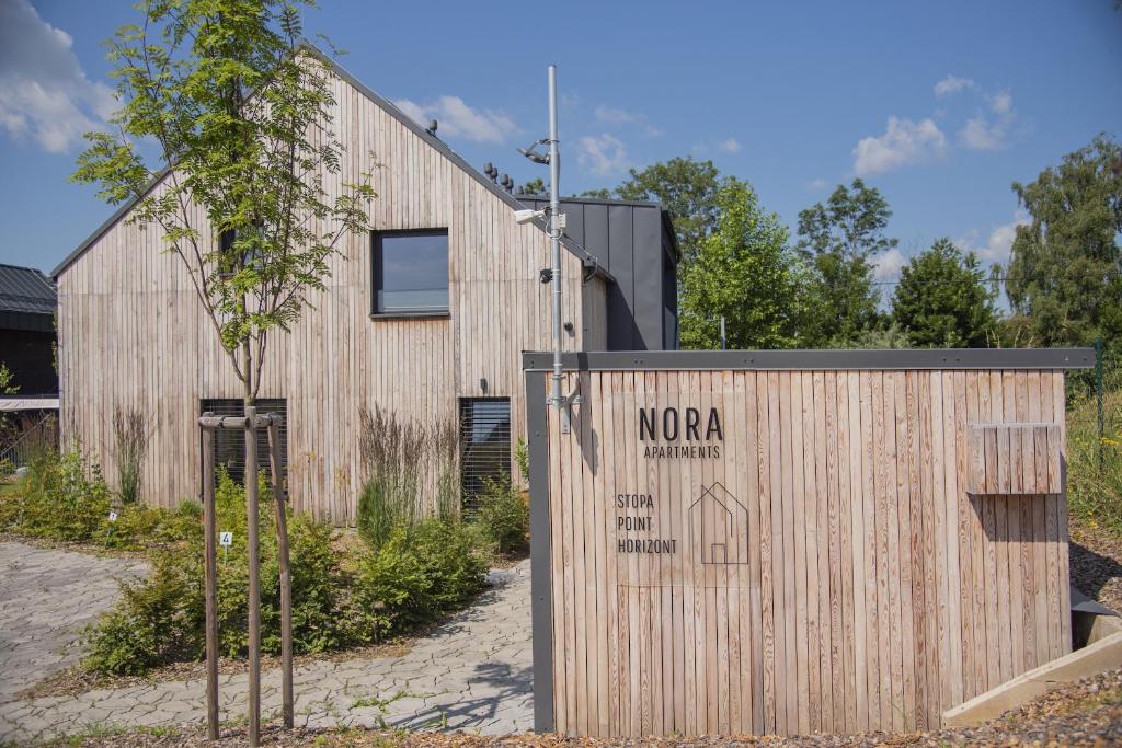 a wooden building with a sign in front of it at Nora Apartments in Dolní Morava