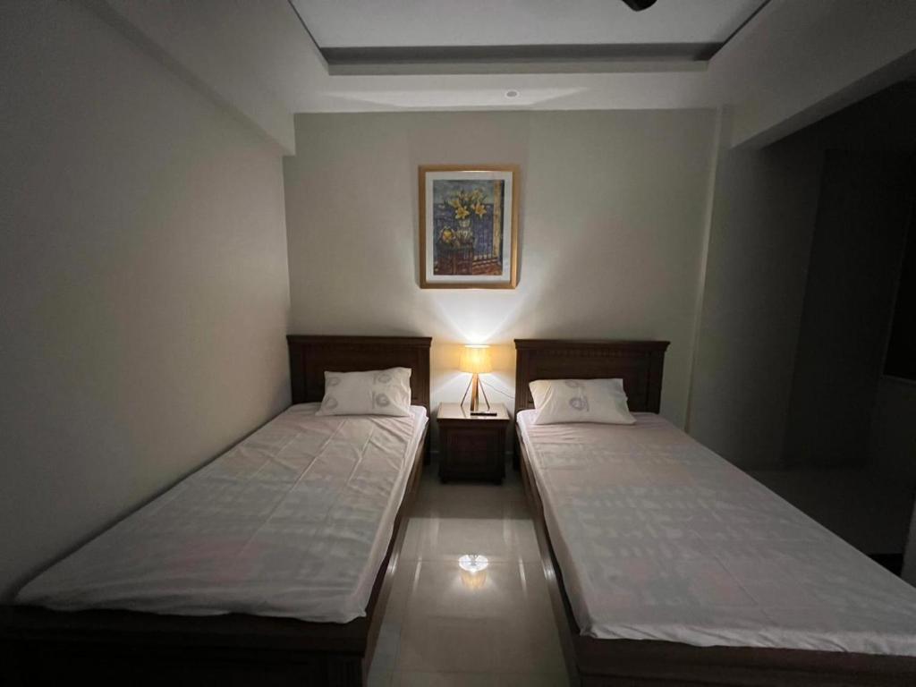 - 2 lits dans une petite chambre avec une lampe dans l'établissement Prestige comforts, à Karachi